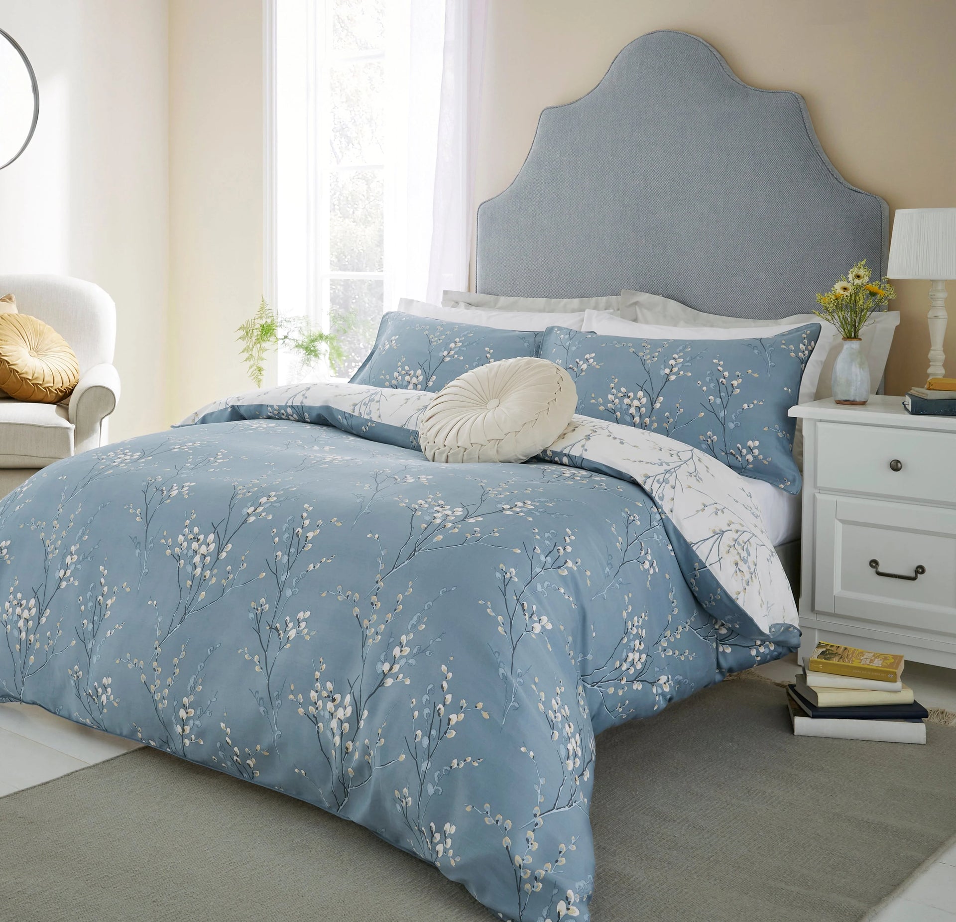 Layered Laura Ashley bedding with quilted bedspread and cushions